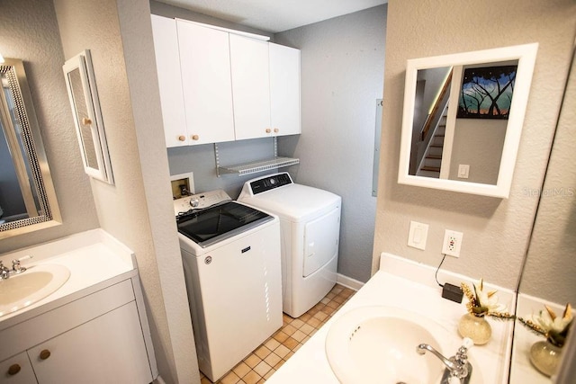 laundry area featuring washer and clothes dryer, laundry area, a textured wall, and a sink