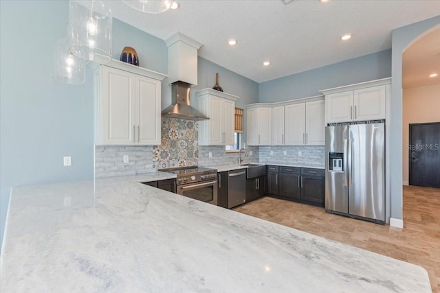 kitchen with white cabinets, backsplash, light stone countertops, and appliances with stainless steel finishes