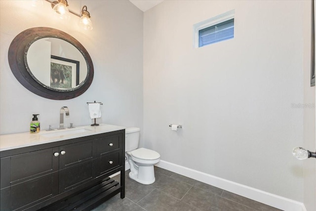 bathroom with baseboards, toilet, vanity, and tile patterned flooring