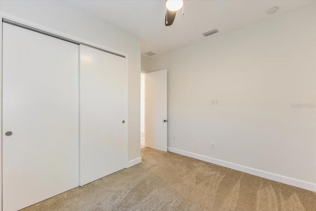 unfurnished bedroom with visible vents, baseboards, carpet, and a closet