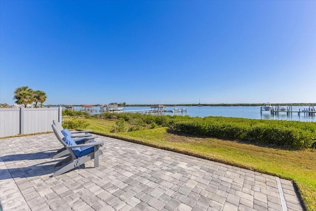 view of patio / terrace with fence and a water view