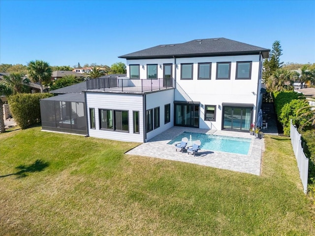 back of house featuring a sunroom, a lawn, a fenced backyard, a balcony, and a patio area