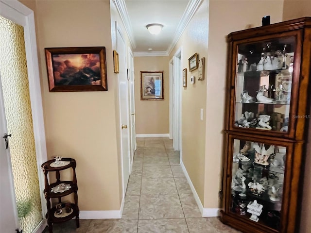 hall with light tile patterned floors, baseboards, and ornamental molding