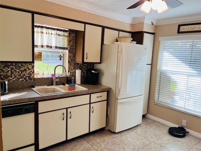 kitchen featuring white appliances, ornamental molding, decorative backsplash, a sink, and dark countertops