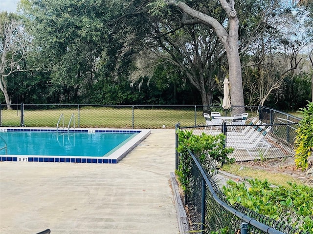 community pool with a yard and fence