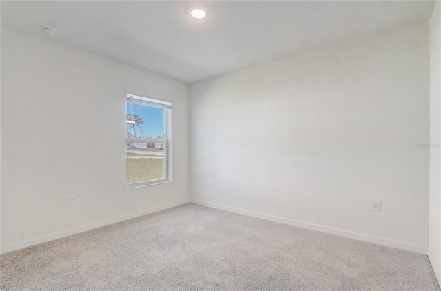 spare room with baseboards and carpet