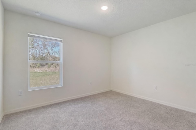 empty room featuring baseboards, carpet floors, and a textured ceiling