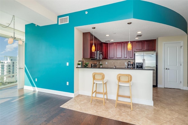 kitchen with dark countertops, visible vents, backsplash, and appliances with stainless steel finishes