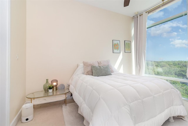 carpeted bedroom with baseboards and a ceiling fan