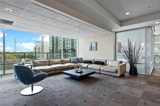 living area featuring visible vents and floor to ceiling windows