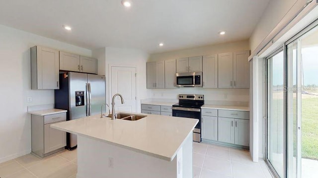 kitchen with a sink, appliances with stainless steel finishes, gray cabinetry, and a healthy amount of sunlight