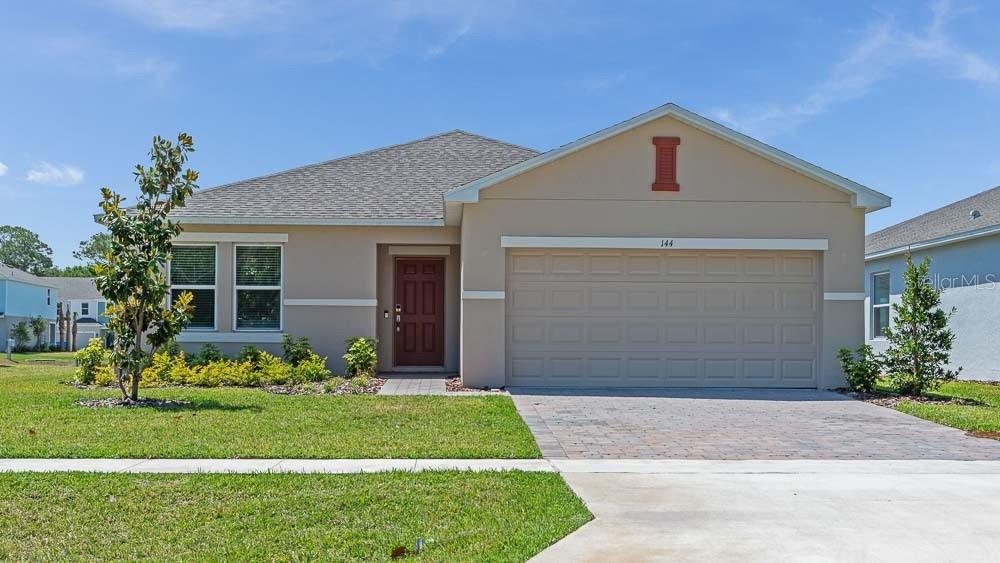 144 Jones Fish Camp Rd, Edgewater, FL 32141 - ranch-style house with driveway, a front lawn, stucco siding, an attached garage, and roof with shingles