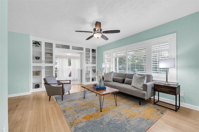 living area featuring baseboards, plenty of natural light, and wood finished floors