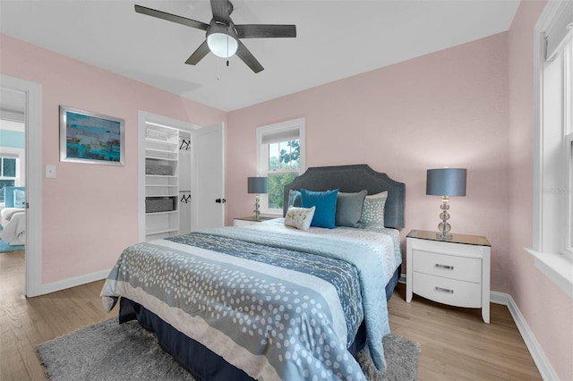 bedroom featuring baseboards, wood finished floors, and a ceiling fan