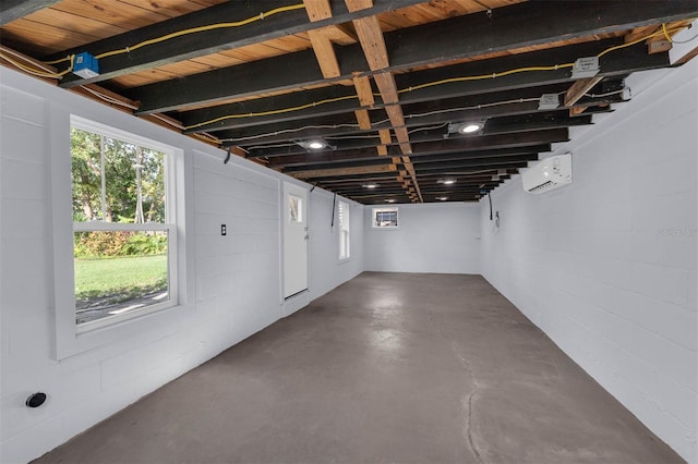 below grade area featuring concrete block wall and a wall unit AC