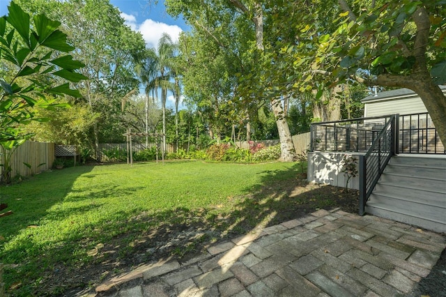 view of yard with a deck, a fenced backyard, and a patio area