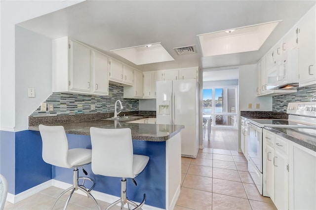 1318 Chebon Ct Unit E-F, Unit E-F, Apopka, FL 32712 - kitchen featuring tasteful backsplash, white appliances, a sink, visible vents, and a peninsula