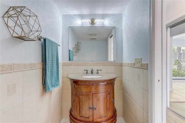 1318 Chebon Ct Unit E-F, Unit E-F, Apopka, FL 32712 - bathroom featuring vanity, wainscoting, and tile walls