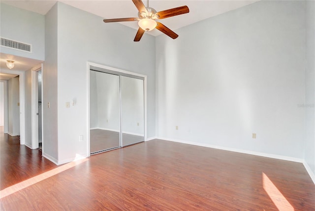 1318 Chebon Ct Unit E-F, Unit E-F, Apopka, FL 32712 - unfurnished bedroom featuring a closet, dark wood-style flooring, baseboards, visible vents, and a towering ceiling