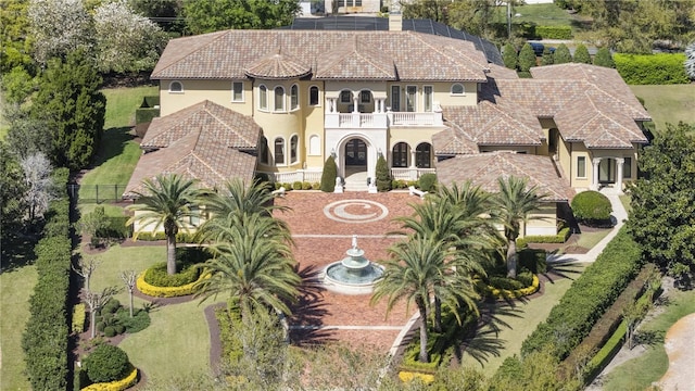 view of front facade featuring stucco siding, a balcony, and a tile roof