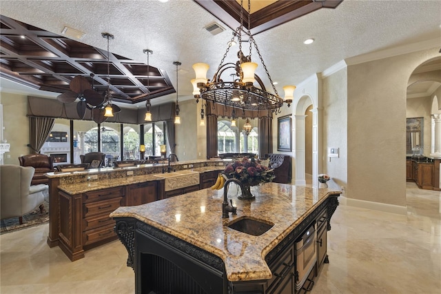 kitchen featuring crown molding, visible vents, arched walkways, and a sink