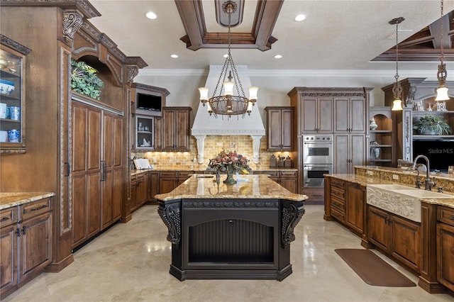 kitchen with pendant lighting, a sink, backsplash, double oven, and light stone countertops