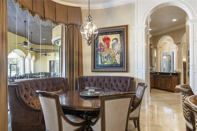 dining space featuring arched walkways, crown molding, a ceiling fan, and decorative columns