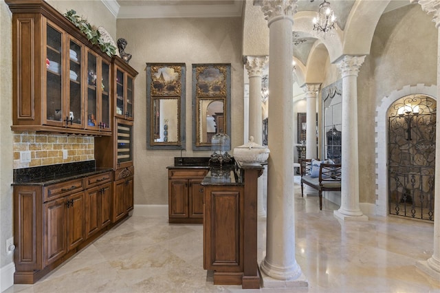 bar featuring arched walkways, backsplash, ornate columns, and ornamental molding