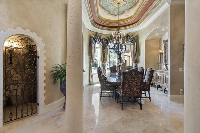 dining area with ornamental molding, arched walkways, a high ceiling, an inviting chandelier, and a raised ceiling