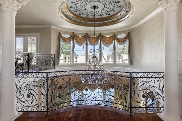 stairs featuring crown molding, decorative columns, and a textured ceiling