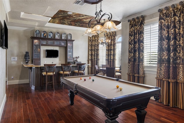 game room with a tray ceiling, wood finished floors, visible vents, and a textured ceiling