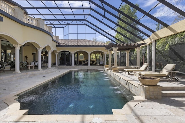 outdoor pool featuring glass enclosure, a patio, and an outdoor fire pit