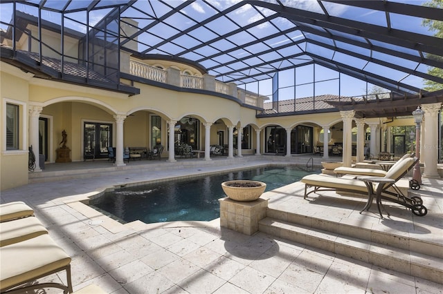 pool with glass enclosure, french doors, and a patio