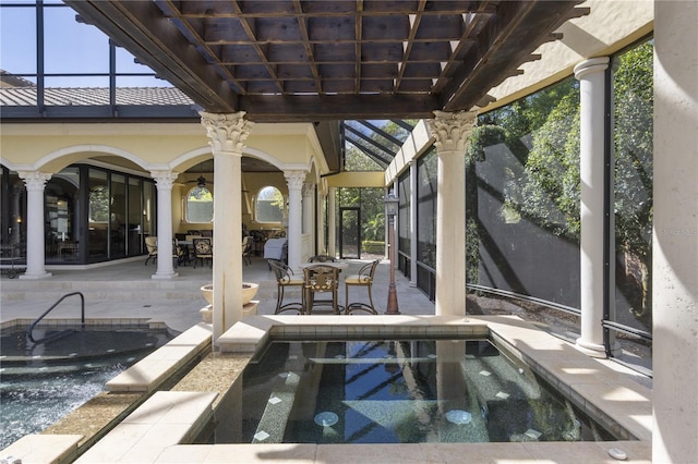 view of pool featuring outdoor dining space, a patio, glass enclosure, an in ground hot tub, and ceiling fan