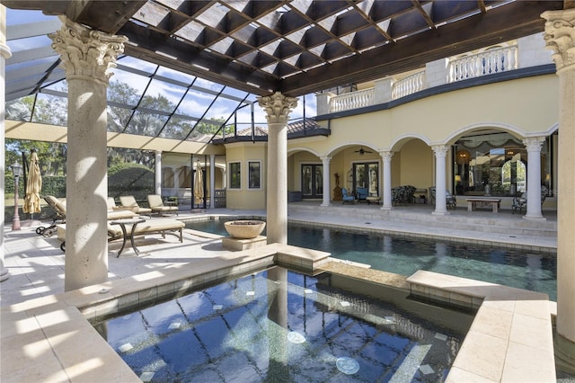 view of pool featuring a lanai, a patio area, and a pool with connected hot tub