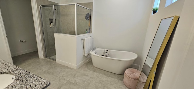 bathroom with a soaking tub, a stall shower, vanity, and baseboards