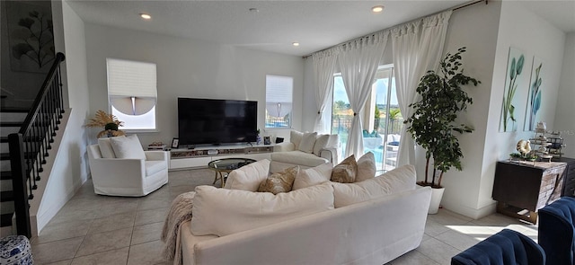 living area featuring light tile patterned floors, recessed lighting, stairs, and baseboards