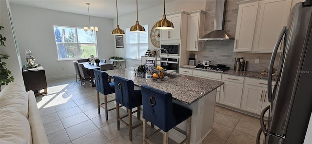 kitchen with a kitchen island, tasteful backsplash, appliances with stainless steel finishes, wall chimney exhaust hood, and light tile patterned flooring