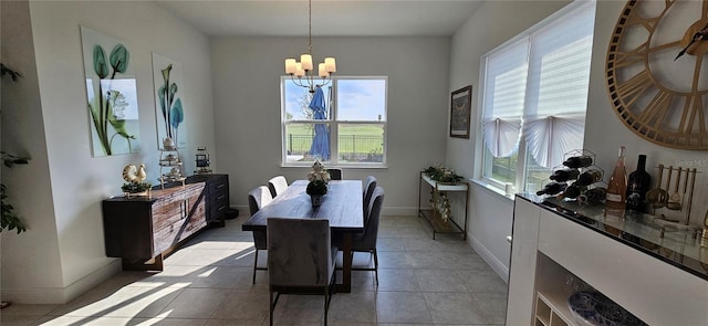 dining area featuring light tile patterned flooring, a notable chandelier, and baseboards