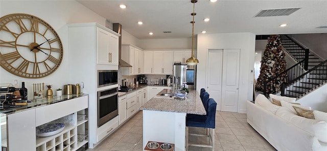 kitchen with light tile patterned floors, visible vents, stainless steel appliances, and open floor plan