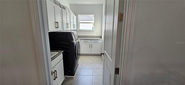 laundry room with washer and dryer, light tile patterned flooring, and cabinet space