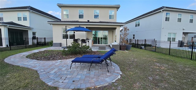 rear view of house featuring a patio area, a yard, a fenced backyard, and stucco siding