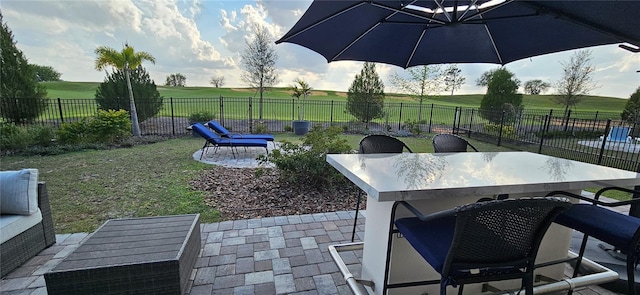 view of patio / terrace featuring a rural view, outdoor dining area, and a fenced backyard