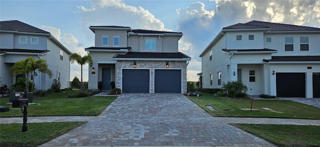 prairie-style house with stone siding, a garage, decorative driveway, and a front yard