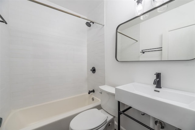 bathroom featuring toilet, bathing tub / shower combination, and a sink