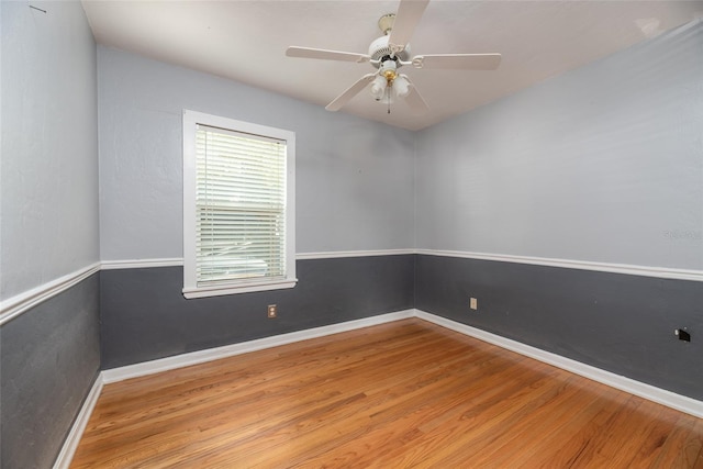 empty room with ceiling fan, baseboards, and wood finished floors