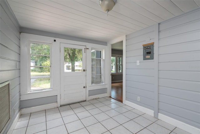 unfurnished sunroom with plenty of natural light, wooden ceiling, and visible vents