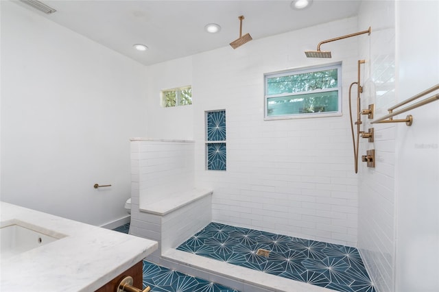 full bath with a wealth of natural light, recessed lighting, and tiled shower