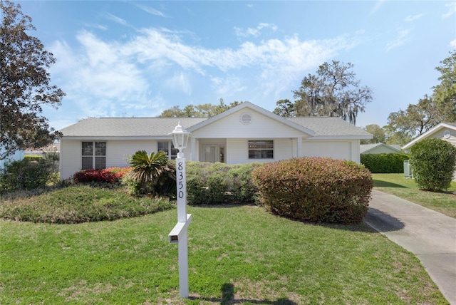 ranch-style home with a garage and a front lawn