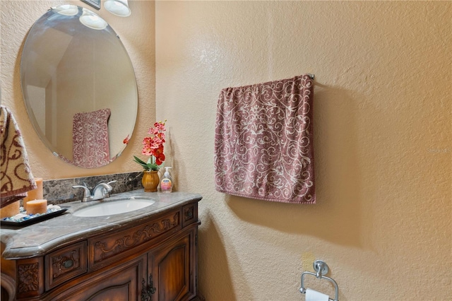 bathroom with vanity and a textured wall